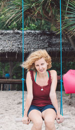 Portrait of smiling woman sitting on land