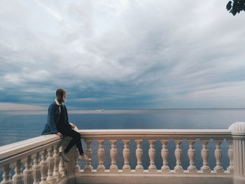 Woman looking at sea against sky