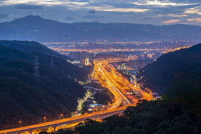 High angle view of illuminated city against sky at night