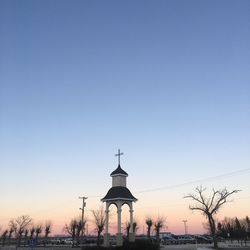 Traditional windmill against clear sky during sunset