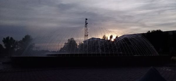 Fountain against sky at sunset