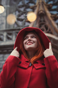 Close up smiling woman in red coat on street portrait picture