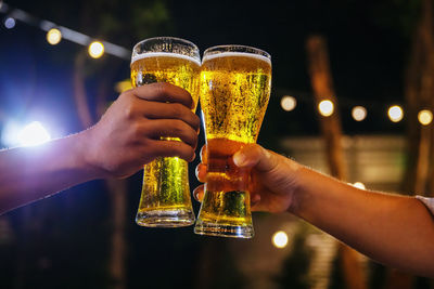 Cropped image of hand holding beer glass