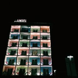 Low angle view of illuminated building against sky at night