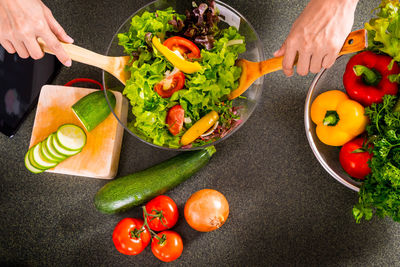 Cropped hands of person mixing salad in bowl