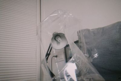 Portrait of young woman holding glass window