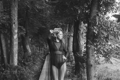 Woman standing on footpath in forest