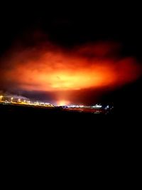 Illuminated city against sky at night