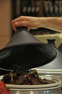 Close-up of person hand lifting domed tray