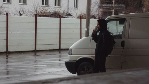 Side view of woman standing in car