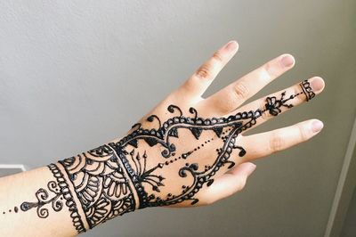 Cropped image of woman with henna tattoo on hand