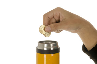 Close-up of hand holding bottle against white background