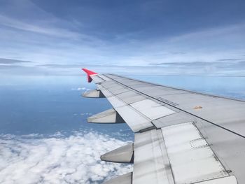 Airplane flying over sea against blue sky