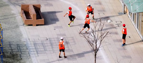 High angle view of children playing soccer on playground