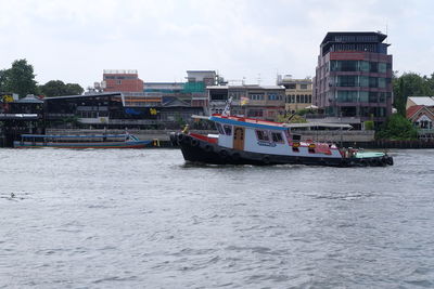 Boats in river with city in background