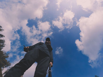 Low angle view of man standing against blue sky