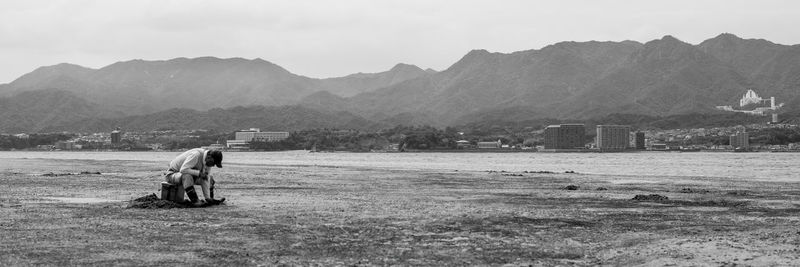 Man on field by mountains against sky