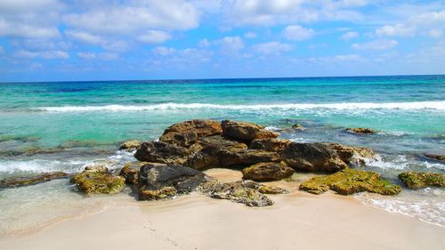 Scenic view of rocks on beach against sky