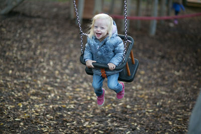 Full length of boy on swing in playground