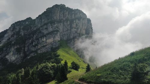 Low angle view of waterfall on mountain against sky