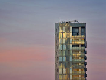 Low angle view of modern buildings against sky during sunset