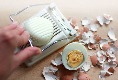 High angle view of boiled eggs and egg cutting tool on table