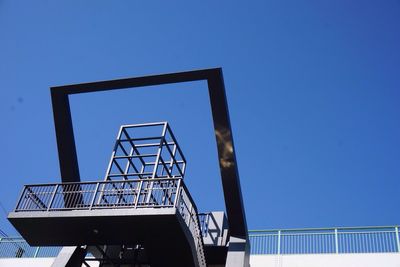 Low angle view of staircase against clear blue sky