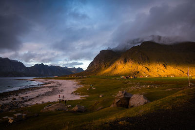 Scenic view of beach and mountains against sunset sky, lofoten, norway