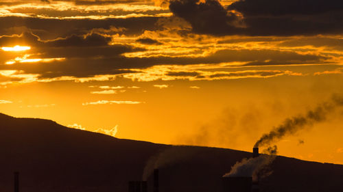 Scenic view of silhouette mountain against orange sky