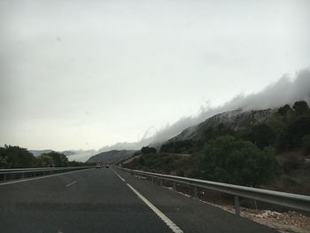 Road passing through mountains against sky