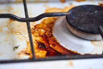 Dirty grease stove with food leftovers. unclean gas kitchen cooktop with greasy spots, fat stains