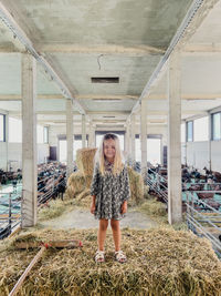 Portrait of young woman standing against building