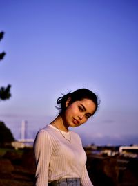 Portrait of smiling woman standing against sky during sunset