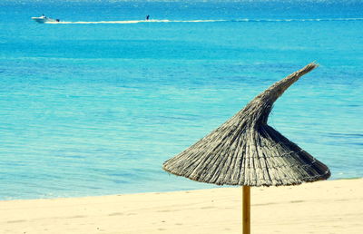 Thatched roof umbrella at beach on sunny day