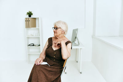 Midsection of woman standing against wall at home