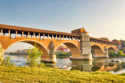 Arch bridge over river against sky