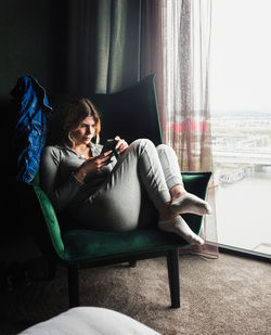 Woman sitting on sofa at home