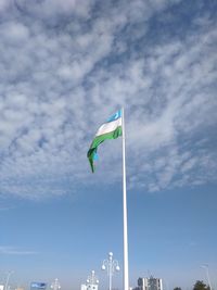 Low angle view of flags against blue sky