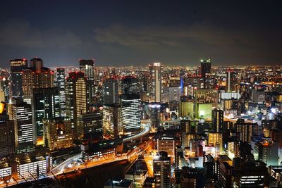 Illuminated buildings in city against sky at night