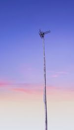 Low angle view of telephone pole against sky at sunset