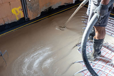 Low section of man riding bicycle on road