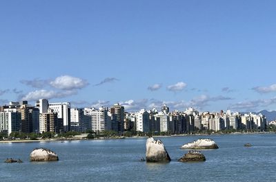 Panoramic view of sea and buildings against sky