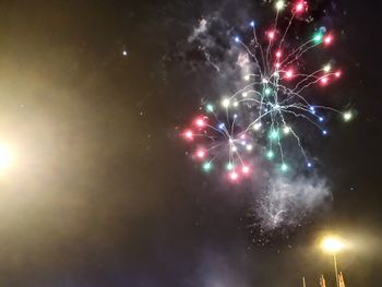 Low angle view of firework display at night