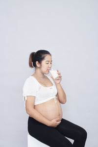 Young woman standing against white background