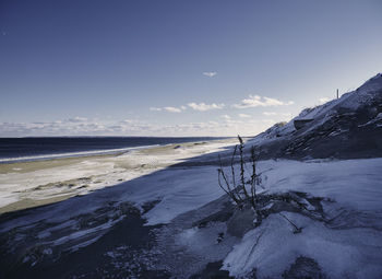 View of snow covered landscape against sea