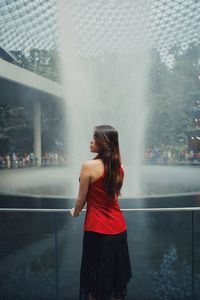 Rear view of woman standing by fountain outdoors