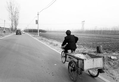 Rear view of man riding padicab