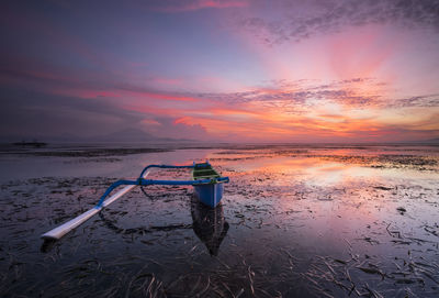 Sunglasses on beach against sky during sunset