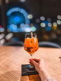 Midsection of woman holding drink on table