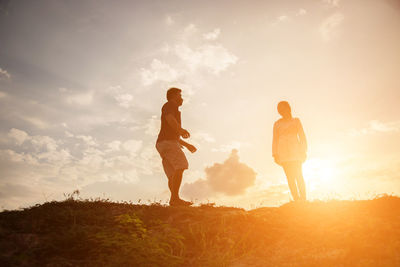 People on field against sky during sunset